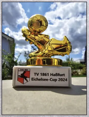 Pokal des Eichelsee-Cup 2024: ein goldener Fußballschuh mit Ball auf einem Sockel mit TVH-Wappen